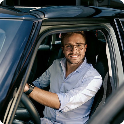 A customer sitting in the driver’s seat of a MINI with the door open.